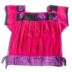 Unique cotton top from Mexico. Pleated with woven fabric and tied hem details.